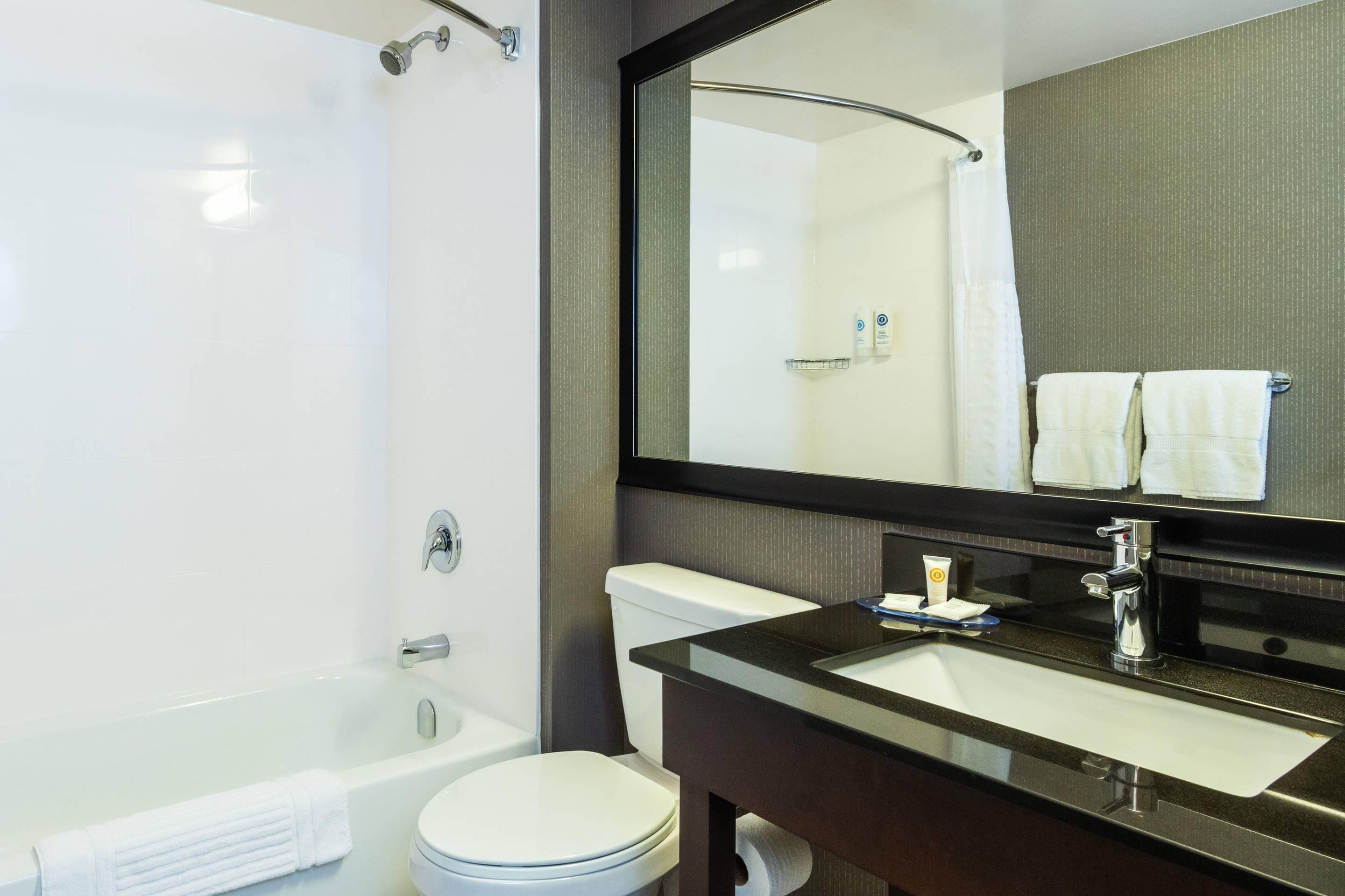 A modern bathroom with a bathtub, toilet, and sink.