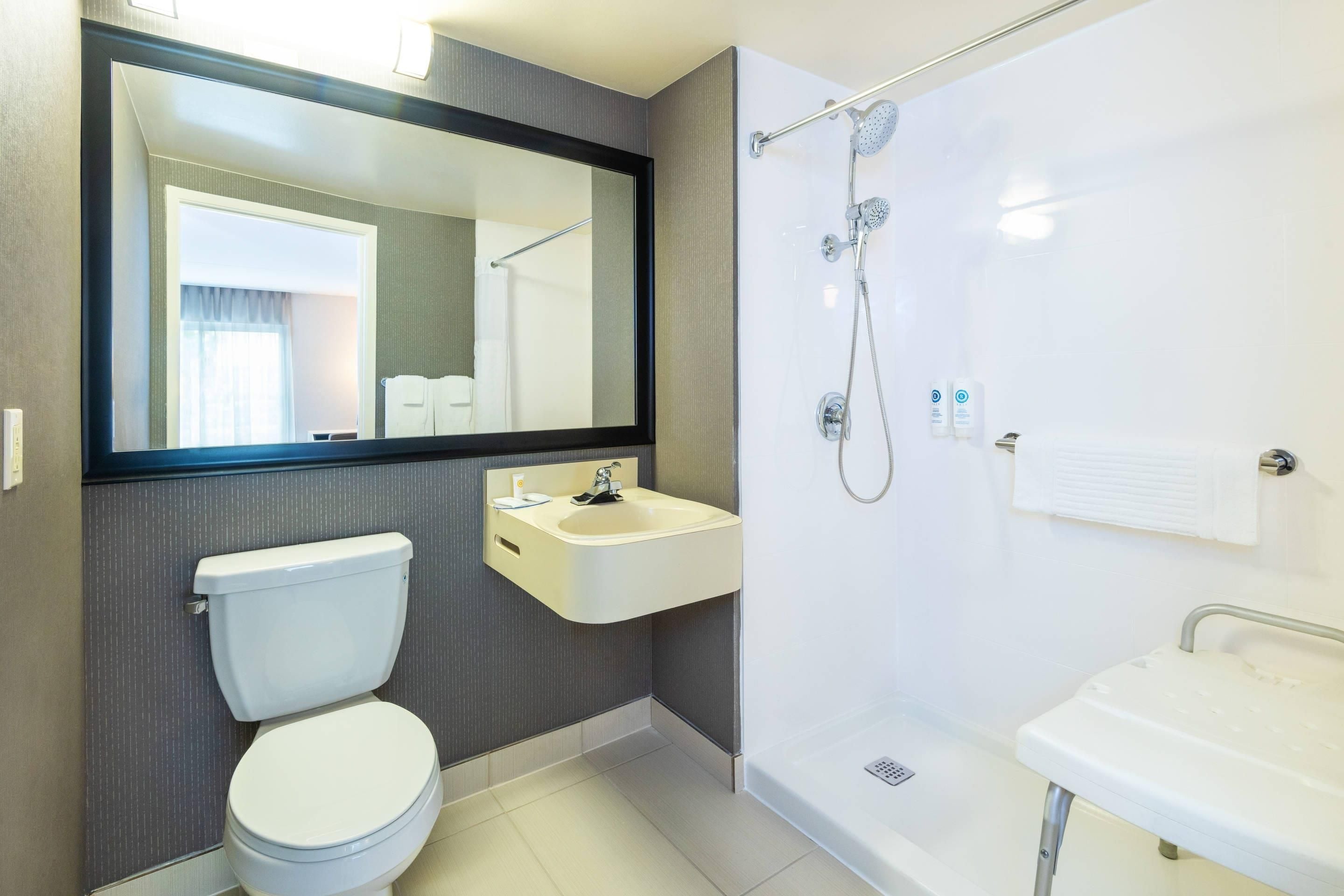 A modern bathroom with a toilet, sink, and shower.