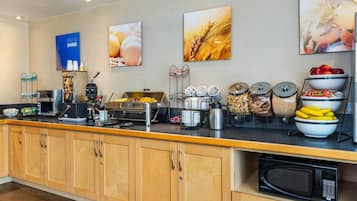 Un comptoir-buffet proposant divers aliments, un espace dédié au café et un four à micro-ondes.