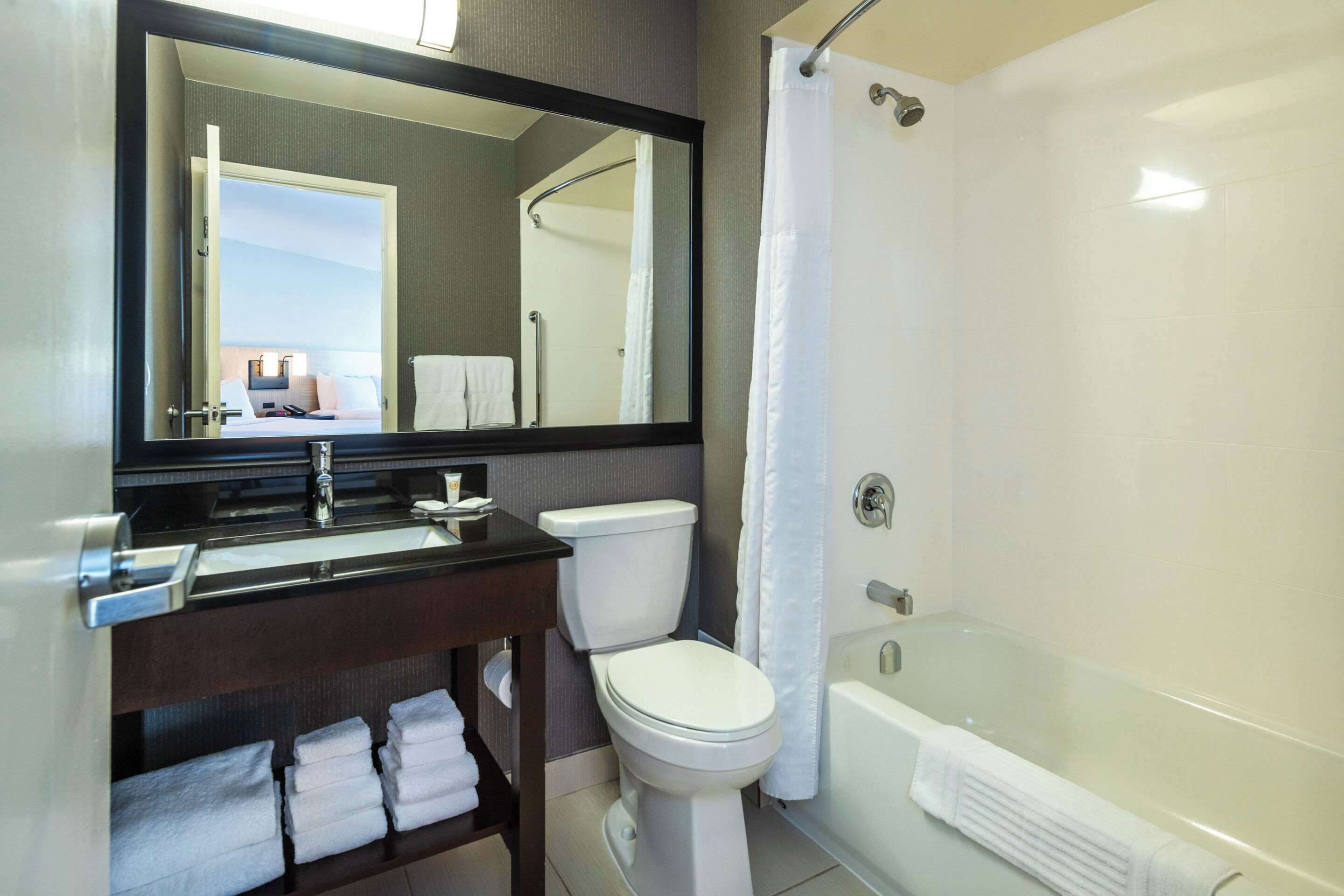 A modern bathroom with a toilet, sink, and bathtub.