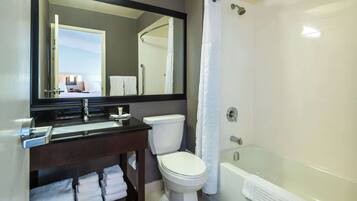 A modern bathroom with a toilet, sink, and bathtub.