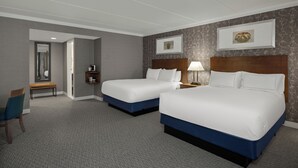 A hotel room with two beds, a bench, a chair, a nightstand, and a wall-mounted picture. - Radisson Hotel Corning (Corning)