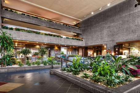 A multi-level atrium with a central garden, multiple floors, and a bar area.