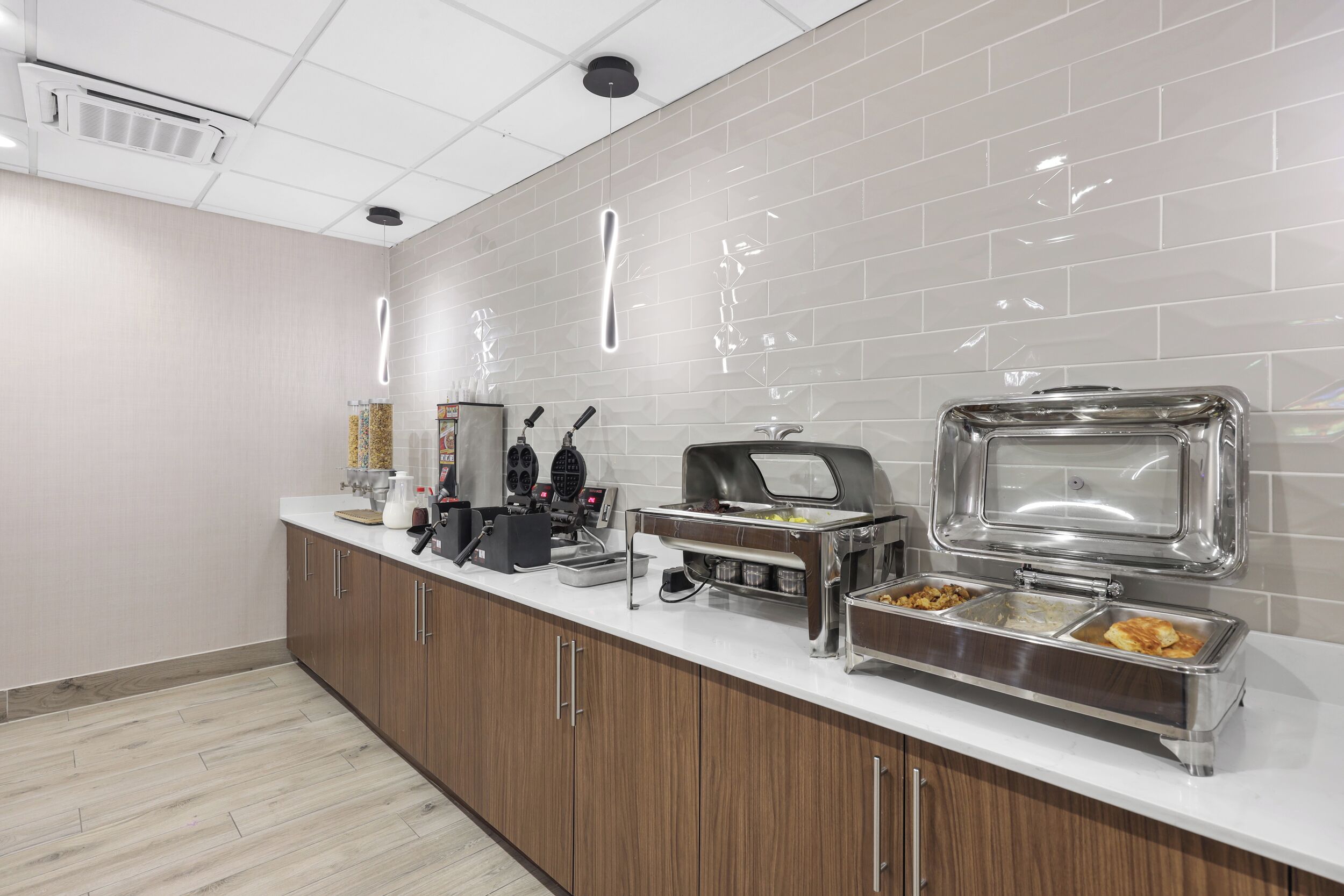 Eine moderne Küche mit weißer Arbeitsplatte, Edelstahlgeräten und einem Buffet.