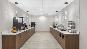 A modern kitchen with wooden cabinets, a central island, and a long countertop. - La Quinta Inn & Suites by Wyndham Nashville Airport/Opryland (Nashville)