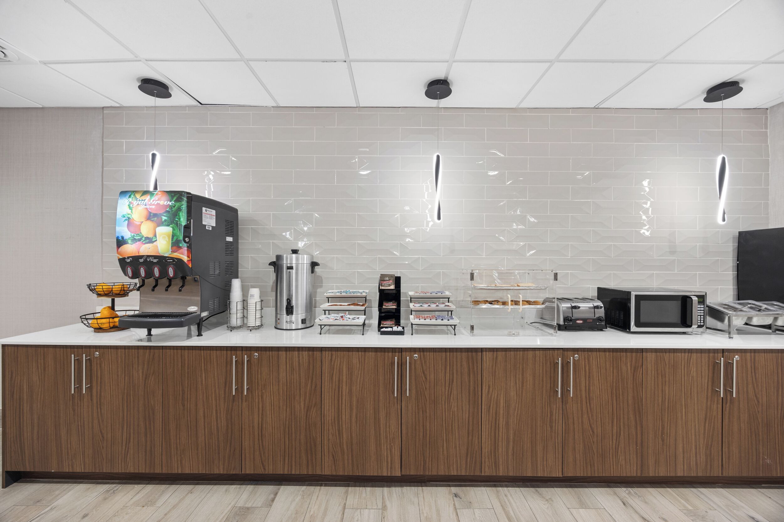 A modern kitchen with a coffee machine, microwave, toaster, and various appliances on a white countertop.