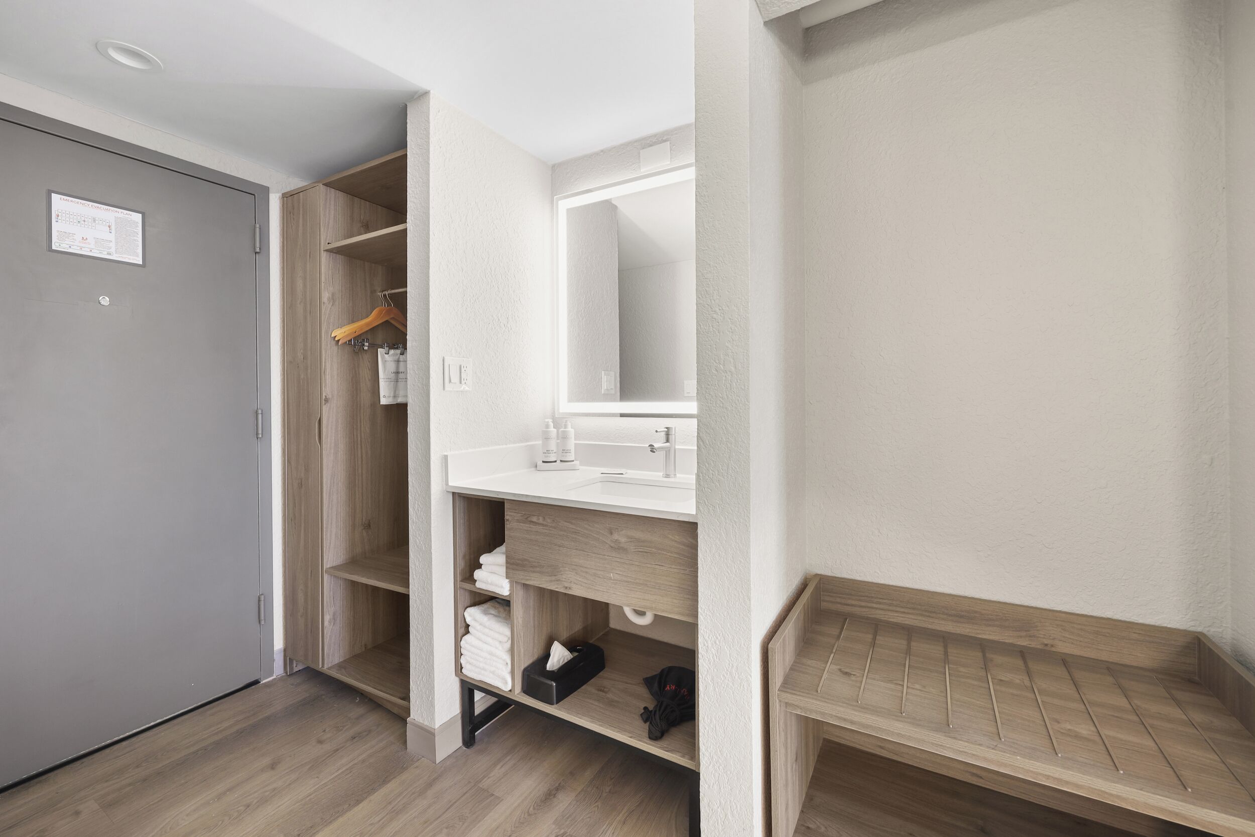 Ein modernes Badezimmer mit einem Holzkosmetikschrank, einem Spiegel und einer Duschkabine.