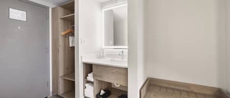 Ein modernes Badezimmer mit einem Holzkosmetikschrank, einem Spiegel und einer Duschkabine.