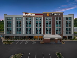 Ein mehrstöckiges Hotel mit den Schildern 'Hawthorn Extended Stay' und 'La Quinta', das ein modernes architektonisches Design mit Flachdach und großen Fenstern aufweist.