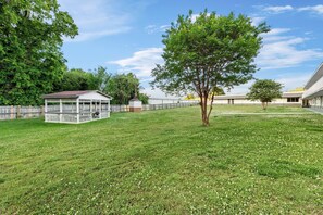 A grassy area with a gazebo, a tree, and a building with a flat roof. - Super 8 by Wyndham Gaffney (Gaffney)