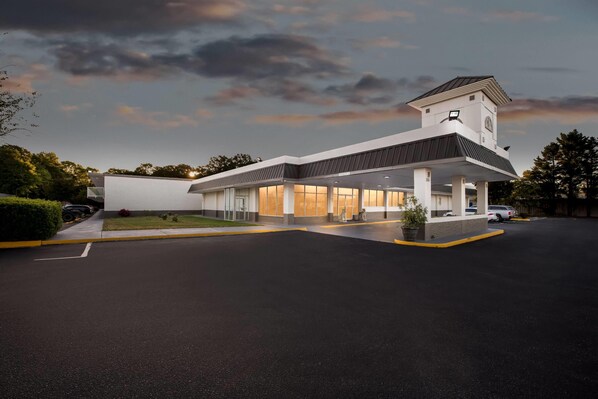 A modern building with a covered entrance, a clock tower, and a parking lot. - Super 8 by Wyndham Gaffney (Gaffney)