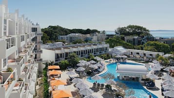 A resort with a swimming pool, sun loungers, and umbrellas.