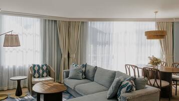 A modern living room with a sectional sofa, round coffee table, and dining area with chairs.