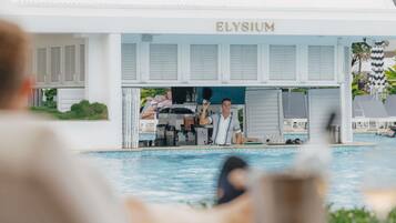 Zona de piscina con bar y un letrero que dice 'ELYSIUM'.