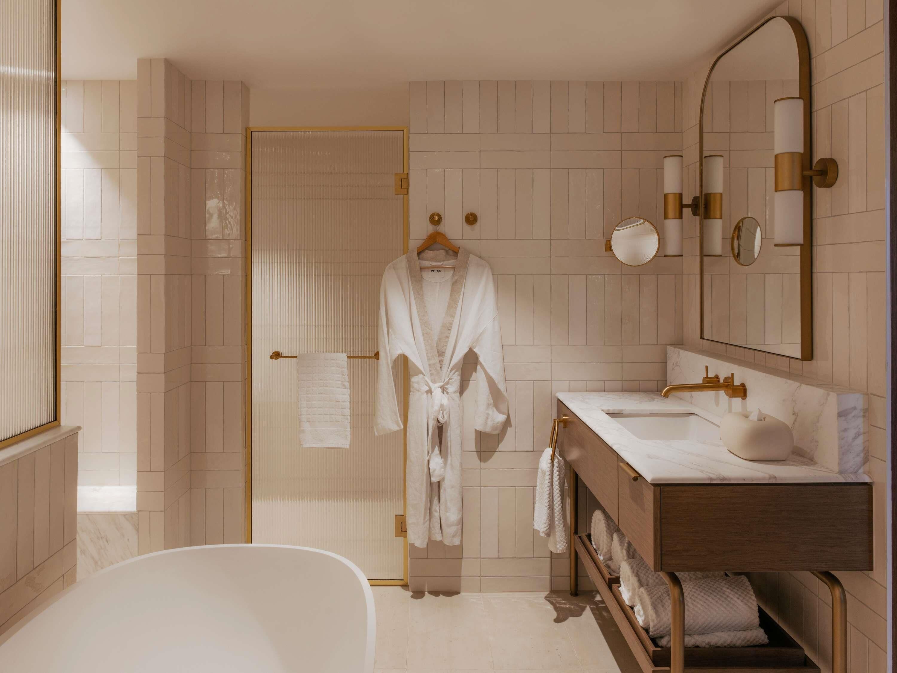Un baño moderno con bañera, tocador con lavamanos y espejo.