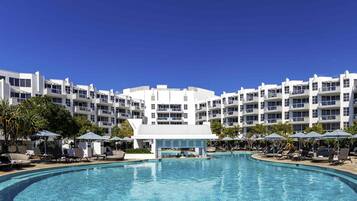 Una piscina al aire libre, cabañas de piscina (de pago), sombrillas