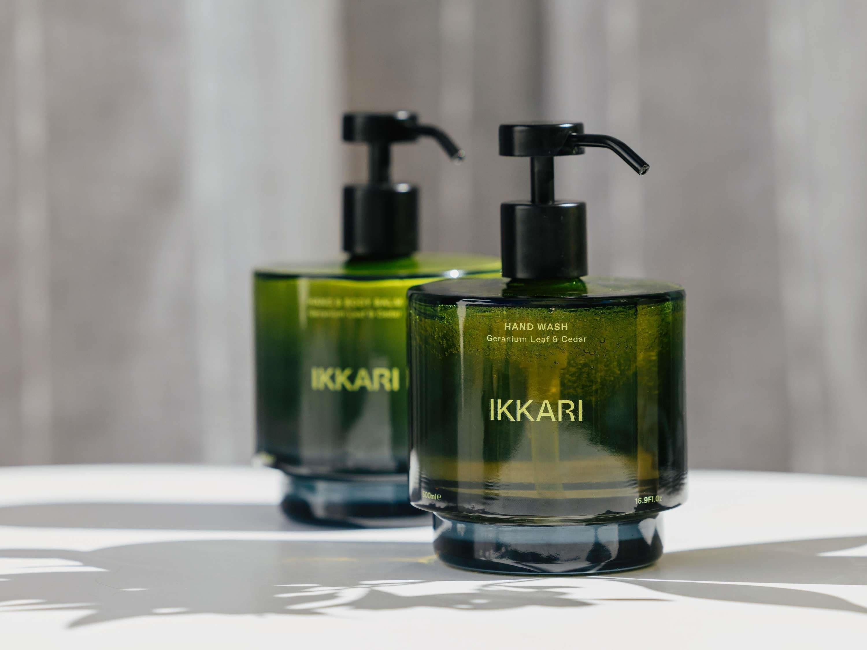 Dos botellas dispensadoras de jabón Ikkari sobre una superficie reflectante.