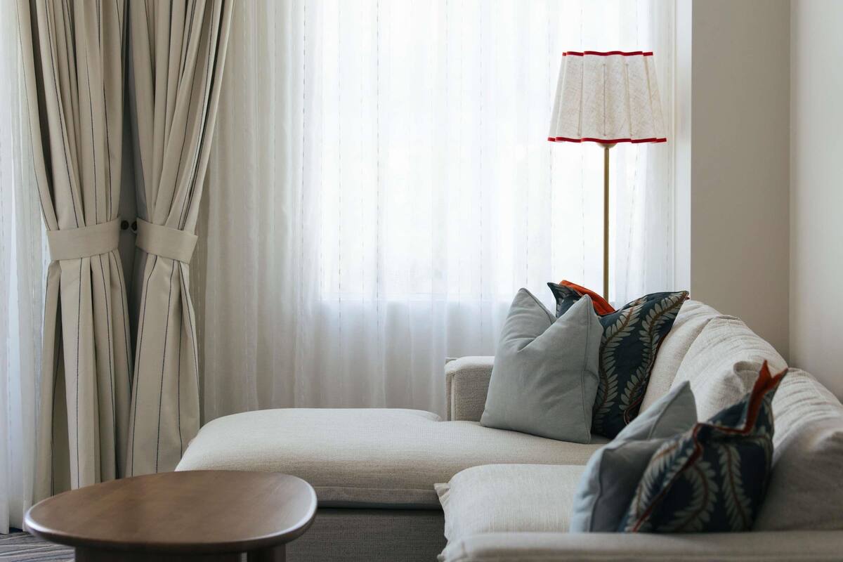 A modern living room with a sofa, a round coffee table, and a floor lamp.