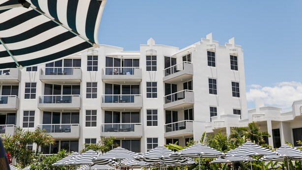 Un hotel de varios pisos con balcones y ventanas grandes.