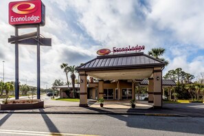 Un hôtel EconoLodge doté d’une entrée couverte, de palmiers et offrant une vue sur un ciel dégagé.