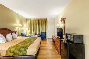 A hotel room with a bed, a television, a dresser, and a desk with a chair. - Econo Lodge Lake City-North (Lake City)