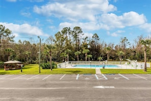 A parking lot with a pool area, a gazebo, and a fence. - Econo Lodge Lake City-North (Lake City)