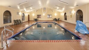 Ein überdachter Bereich mit klarem Wasser, umgeben von Liegestühlen und einem Schwimmbecken.
