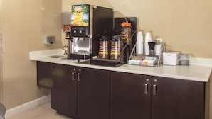 Eine Küchenzeile mit Kaffeemaschine, Kaffeeautomaten und Kaffeezubereiter.