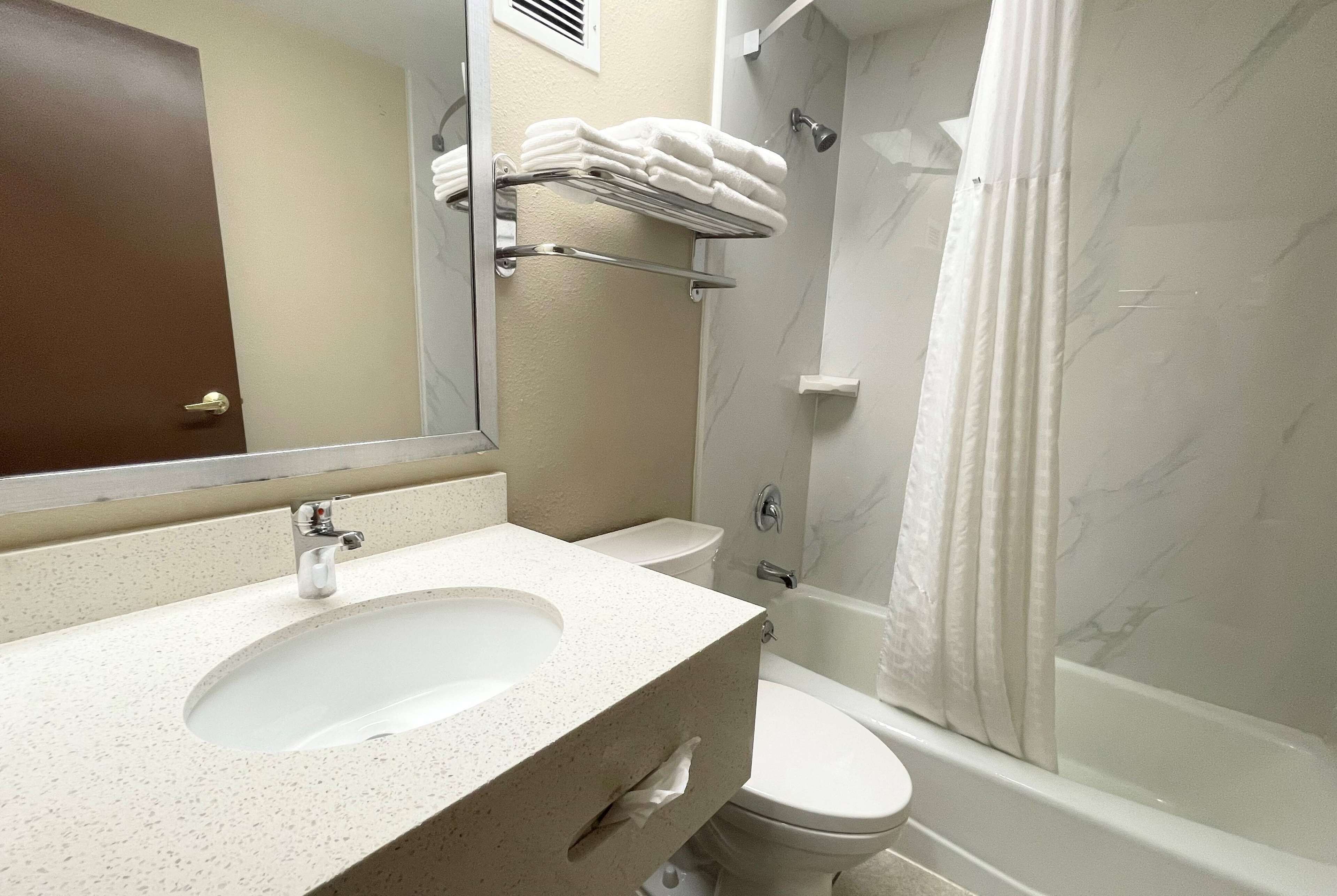 A bathroom with a sink, toilet, and shower.