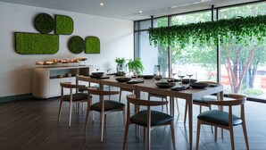 A modern dining area with a long table, several chairs, and a buffet counter. - The Ven at Embassy Row, Washington, D.C., a Tribute Portfolio Hotel (Washington)
