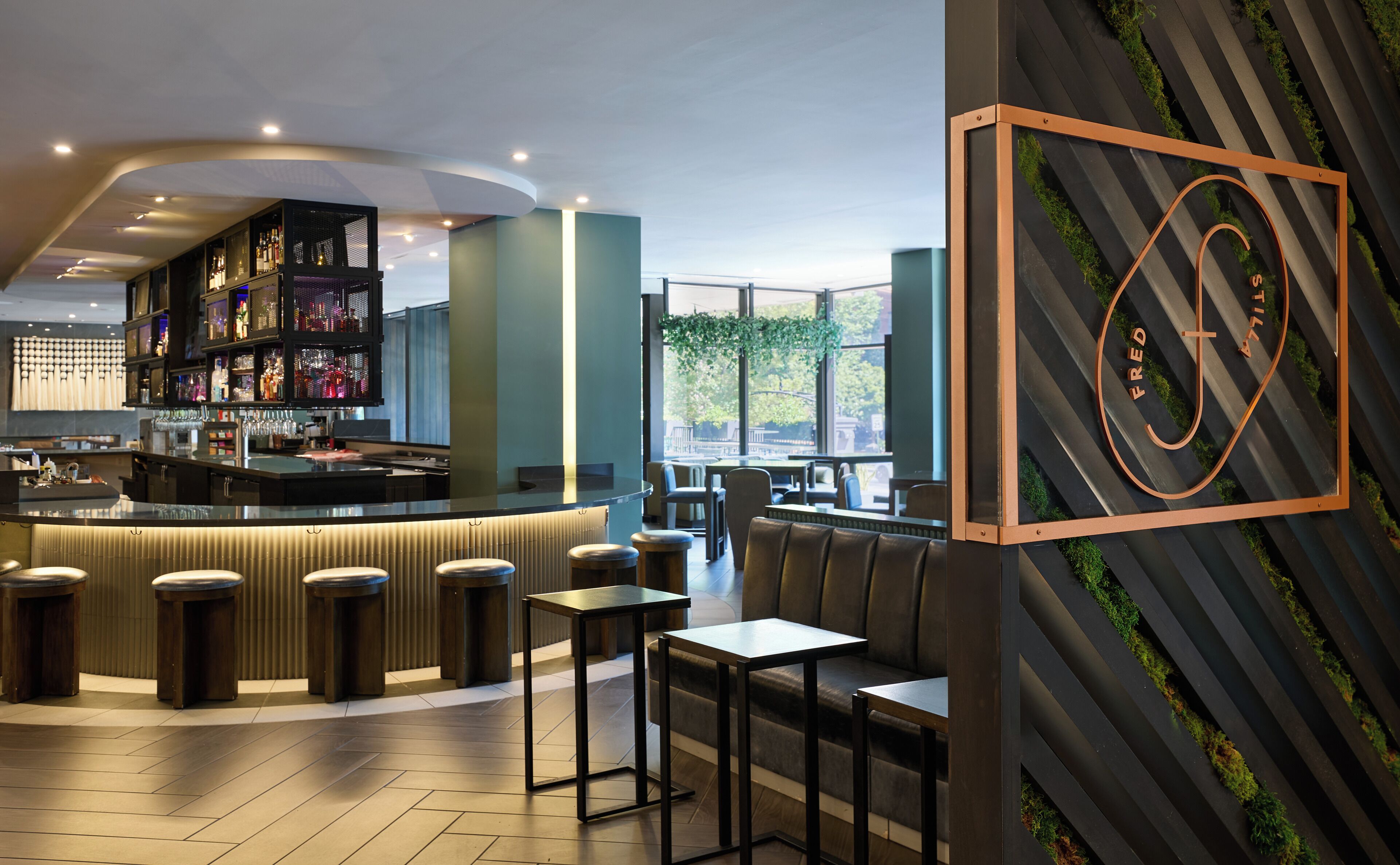 A modern bar area with a counter, stools, and seating.