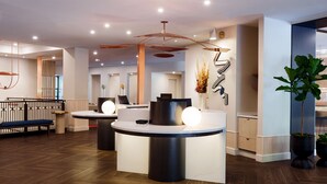 A modern reception area with a central desk, seating, and decorative elements. - The Ven at Embassy Row, Washington, D.C., a Tribute Portfolio Hotel (Washington)