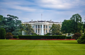 A large, symmetrical building with a central fountain, surrounded by well-manicured lawns and trees. - The Ven at Embassy Row, Washington, D.C., a Tribute Portfolio Hotel (Washington)