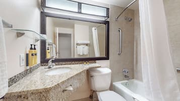 A bathroom with two sinks, a toilet, a bathtub, and a shower.