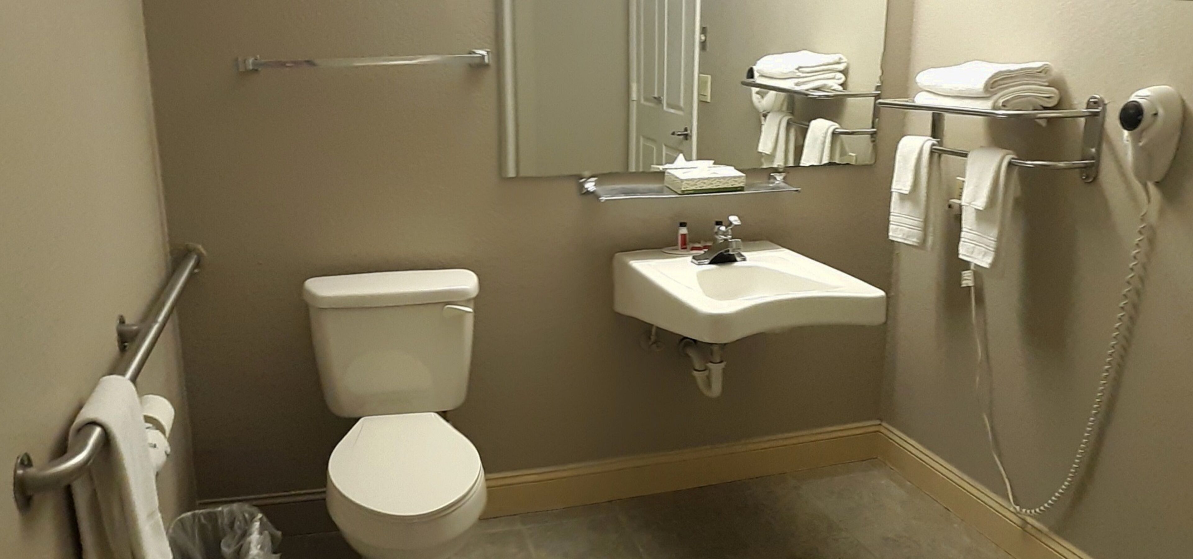 Ein Badezimmer mit Toilette, Waschbecken und Handtuchhalter.