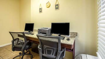 A workspace with two computers, a printer, and two chairs.