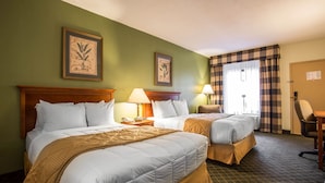 Une chambre d’hôtel avec deux lits, un bureau, une chaise et deux lampes.
