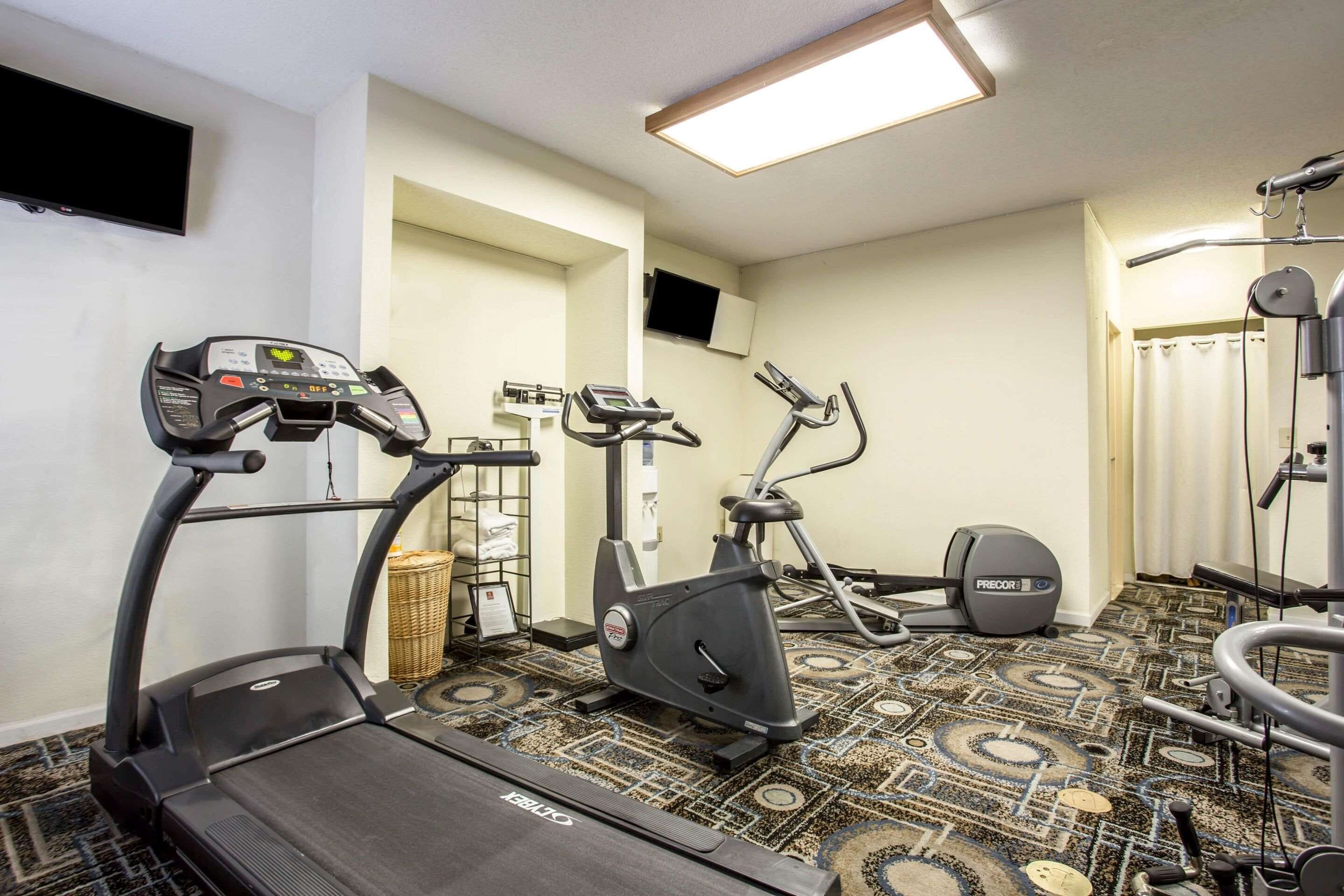Une salle de sport équipée de tapis de course, de vélos d’appartement et d’appareils de musculation.