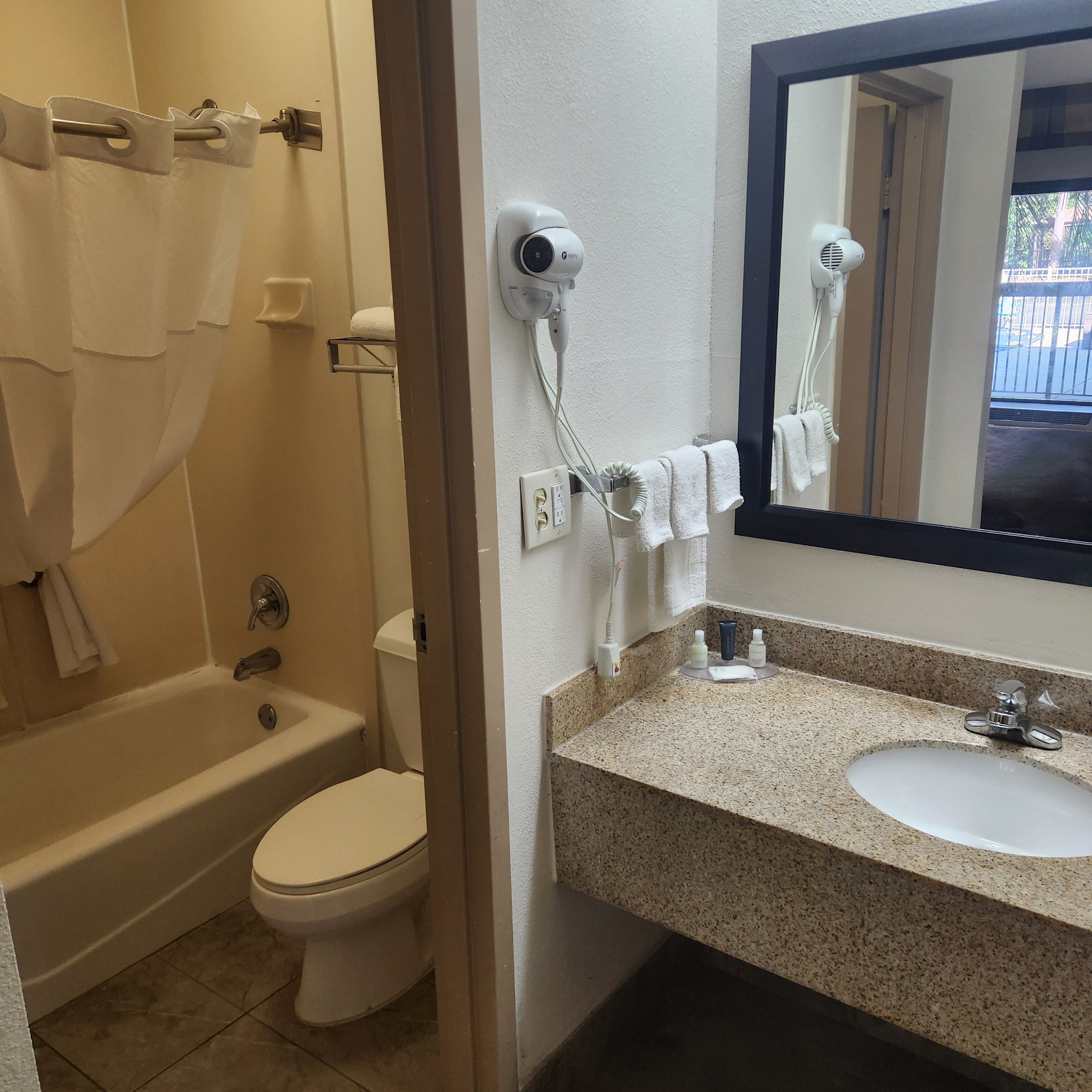Une salle de bain avec une baignoire, des toilettes et un lavabo avec un miroir.