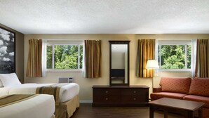A hotel room with two beds, a sofa, a dresser, and a mirror. - Super 8 by Wyndham Brockville (Elizabethtown-Kitley)