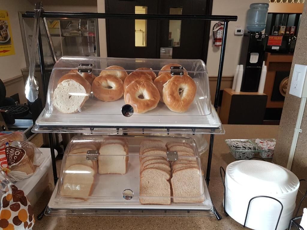 Mostrador de panadería con bagels y pan en rebanadas.
