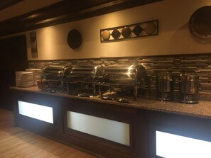 A buffet setup with multiple grills and coffee dispensers.