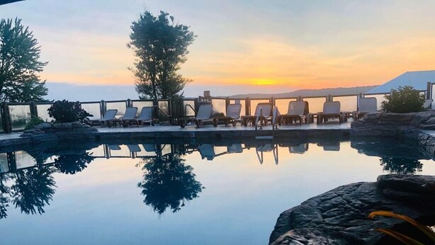 A serene pool area with lounge chairs and a clear view of the sunset. - Fourwinds Lakeside Inn & Marina (Bloomington)