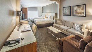A hotel room with a bed, a sofa, a desk, and a TV. - DoubleTree by Hilton Hotel Nanuet (Nanuet)