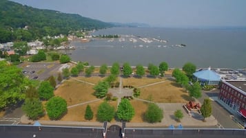 A waterfront view with a parking lot, trees, and a building with a blue roof.