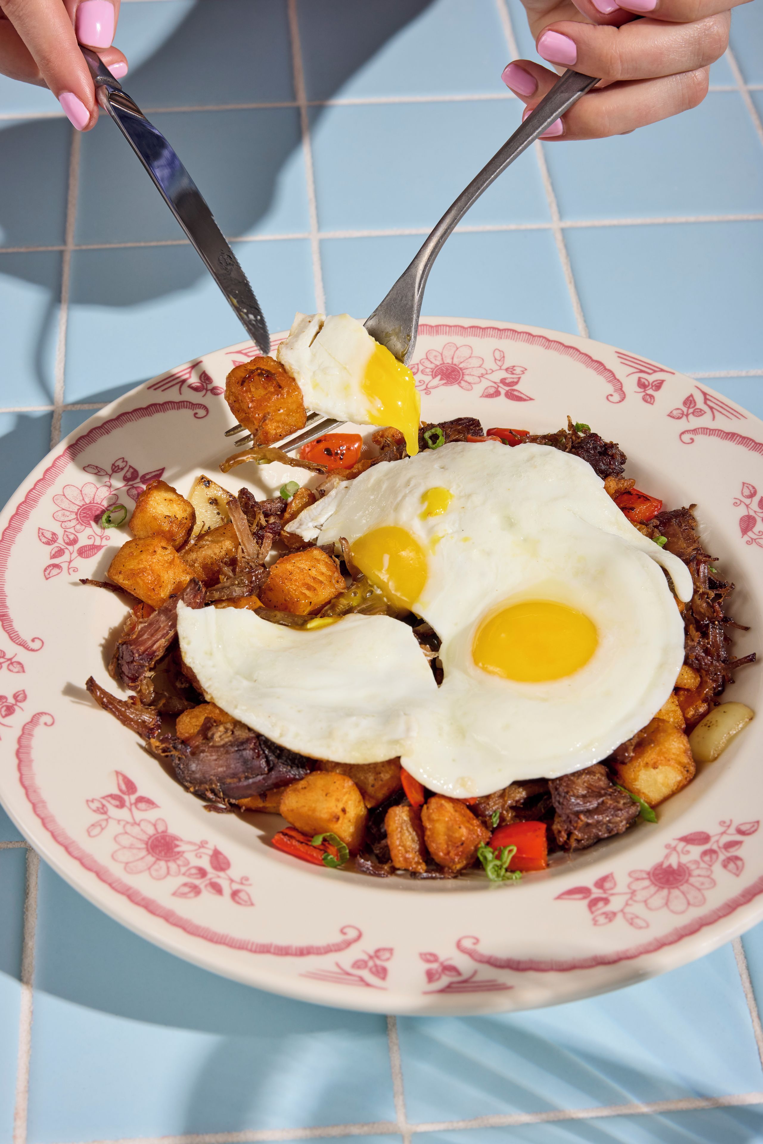 Un plato de comida con un huevo frito, carne y verduras.