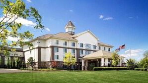 A large, multi-story hotel with a prominent tower, a covered entrance, and a well-maintained lawn. - DoubleTree by Hilton Hotel Nanuet (Nanuet)