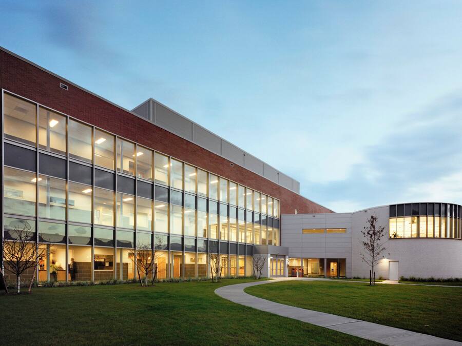 A modern building with large glass windows, a brick facade, and a curved section.