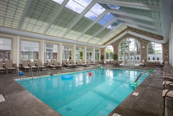 Una piscina techada, sillones reclinables de piscina