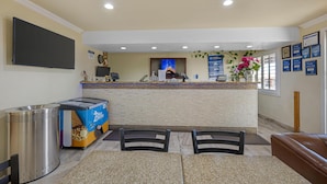 A reception area with a counter, chairs, a trash bin, and a Blue Bell ice cream display.